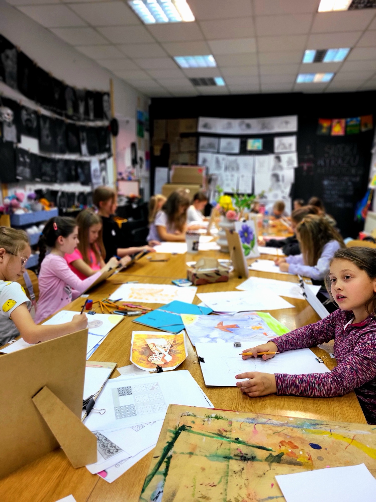 Grupa szkolna na warsztatach artystycznych Academy of Art Ełk przy wspólnym stole